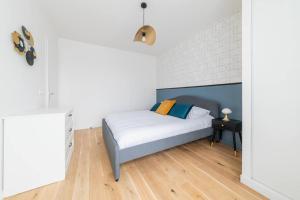 a small bedroom with a bed and a table at L'Elégante Oasis - grand T2 aux portes de Paris in Saint-Ouen
