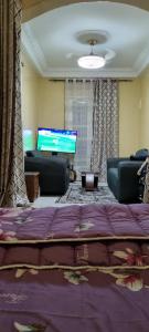 sala de estar con cama y TV de pantalla plana en Villa Lumière, en Dakar