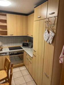 een kleine keuken met houten kasten en een koelkast bij Ferienwohnung Alex in Nusplingen