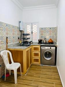 uma cozinha com um fogão e uma máquina de lavar roupa em Julie's AIRPORT Apartment em Marraquexe