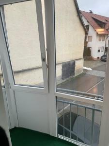 an open door with two windows in a house at Ferienwohnung Alex in Nusplingen