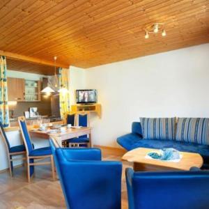 Tofererhof في باد هوفغاستين: غرفة معيشة مع أريكة زرقاء وطاولة