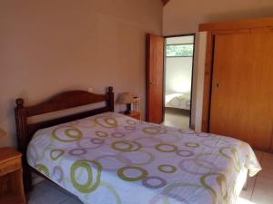 a bedroom with a bed with a purple and green comforter at Cabañas casanostra in Merlo