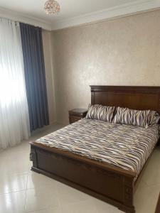 a bedroom with a large bed with a wooden headboard at Appartement De Luxe A Wilaya De Tetouan in Tétouan