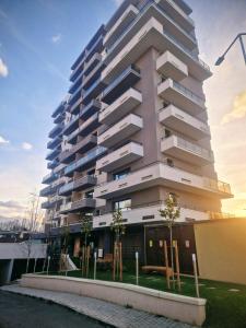 een hoog appartementencomplex met bomen ervoor bij Save Relaxing Residence Brasov in Braşov