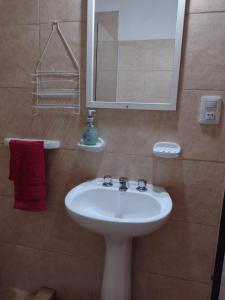 a bathroom with a white sink and a mirror at Cabañas casanostra in Merlo