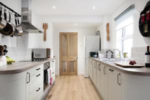 uma cozinha com armários brancos e piso em madeira em Sandbed House - Sleeps 6 em Bristol