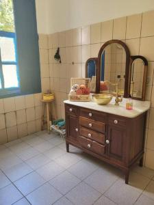 ein Bad mit einem Waschbecken und einem Spiegel in der Unterkunft Fazenda centenária no Sul de MG 