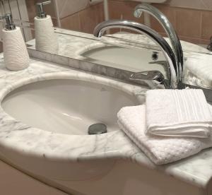 a bathroom sink with a white towel and a faucet at Opera in Love in Verona