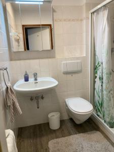 W łazience znajduje się umywalka, toaleta i lustro. w obiekcie Panoramablick über den See w mieście Bad Segeberg
