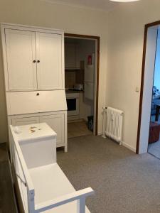 uma cozinha com um armário branco e uma cadeira branca em Panoramablick über den See em Bad Segeberg