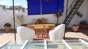a patio with a table and chairs on a balcony at Riad en el corazón de la Medina in Tétouan