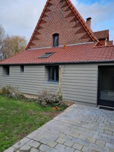 een huis met een stenen dak en een garage bij Gîte du bocage in Buysscheure