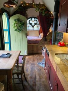 a kitchen with a table and a bed in a room at Enchanting Hand Painted Tabernacle with Hot Tub in Bude