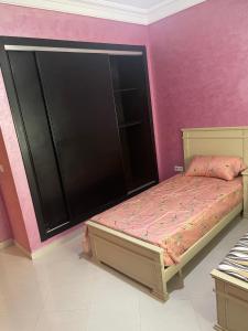 a bedroom with a bed and a pink wall at Appartement De Luxe A Wilaya De Tetouan in Tétouan