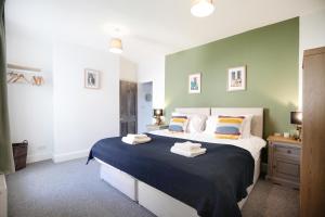 a bedroom with a large bed with a blue blanket at Sandbed House - Sleeps 4 to 6 in Bristol