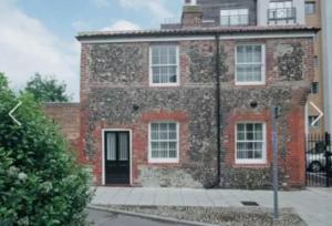 an old brick building with a black door at Detached Pet Friendly Cottage, 2 parking spaces in Norwich