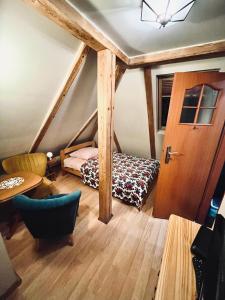 ドゥシュニキ・ズドルイにあるNoclegi u Ewyのベッド1台、ドア、テーブルが備わる客室です。