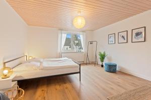 a white bedroom with a bed and a window at GIPFELSTÜRMER Winterberg-Niedersfeld mit Infrarotsauna, Yoga, Netflix, WLAN in Winterberg