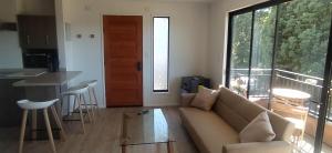 - un salon avec un canapé et une grande fenêtre dans l'établissement Moderno departamento con balcón en IslaTeja, Valdivia, à Valdivia