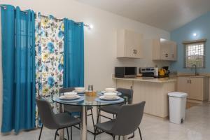 eine Küche und ein Esszimmer mit einem Tisch und Stühlen in der Unterkunft Osmax Oasis/One bedroom in Discovery Bay