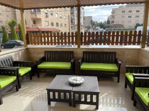 a patio with benches and a table and a fence at Gather 'n' Gab Gateway in Amman