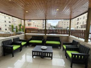 einem Pavillon mit Bänken und einem Tisch auf einer Terrasse in der Unterkunft Gather 'n' Gab Gateway family apartment in Amman