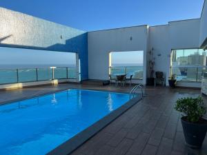 a swimming pool with a view of the ocean at Ocean Flat com vista pro mar 604 in Vila Velha