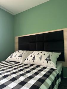 - une chambre avec un lit noir et blanc et des oreillers dans l'établissement BART APARTMENTS Veľká Lomnica, à Veľká Lomnica