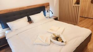 a bed with two towels and shoes on it at Save Relaxing Residence Brasov in Braşov