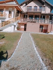 a house with a walkway in front of it at Casa din Deal Isverna Mehedinți in Turtaba