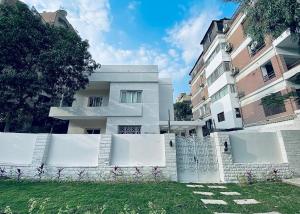 a white fence in front of a white building at Rafiki - Guest House in Cairo