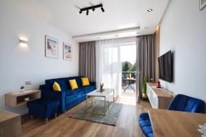 a living room with a blue couch and a tv at Viss Mielno in Mielno