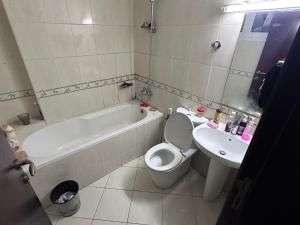 a bathroom with a tub and a toilet and a sink at Ladies Hostel in Ajman سكن بنات بعجمان in Ajman 