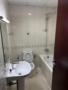 a bathroom with a toilet and a sink and a shower at Ladies Hostel in Ajman سكن بنات بعجمان in Ajman 