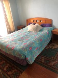 een bed met een quilt en een kussen erop bij casa interior in Viña del Mar