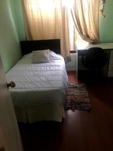 een slaapkamer met een bed, een raam en een bureau bij casa interior in Viña del Mar