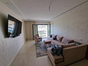 een woonkamer met een bank en een flatscreen-tv bij Luxe Appartement in Tetouan in Tetouan