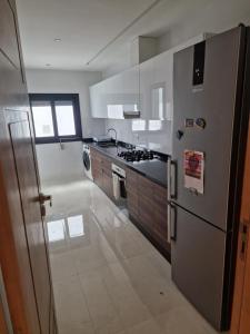 a kitchen with a stainless steel refrigerator and a stove at Luxe Appartement in Tetouan in Tétouan