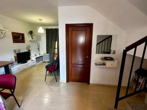 a living room with a wooden door and a table at Casa rural Campiña de Sevilla Tranquila y familiar 