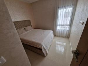 een kleine slaapkamer met een bed en een raam bij Luxe Appartement in Tetouan in Tetouan