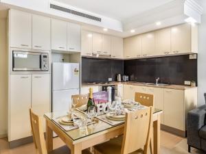 a kitchen with a table with chairs and a refrigerator at Good Value Convenient City Central 2BR Apt in Brisbane