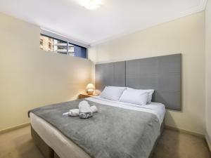 a bedroom with a bed with a stuffed animal on it at Good Value Convenient City Central 2BR Apt in Brisbane