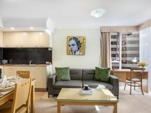 a living room with a couch and a table at Good Value Convenient City Central 2BR Apt in Brisbane