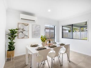 a white dining room with a white table and chairs at 4BR Newly furnished Cozy house Brownsplain in Browns Plains +16 photos
