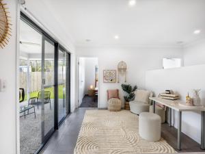 a living room with white walls and glass doors at 4BR Newly furnished Cozy house Brownsplain in Browns Plains