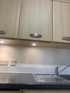 a kitchen counter with a sink and wooden cabinets at Aspect apartments in Chesham
