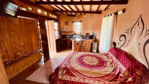 a bedroom with a bed in a room with a kitchen at Bio Chalé Carrancas in Carrancas