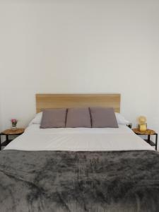 a bedroom with a large white bed with two tables at Ático con vistas al mar in Vícar