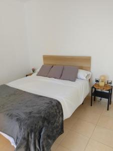 a bedroom with a large white bed and a table at Ático con vistas al mar in Vícar +26 photos